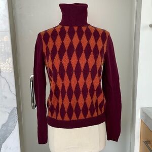 Turtleneck with maroon and orange pattern on front.